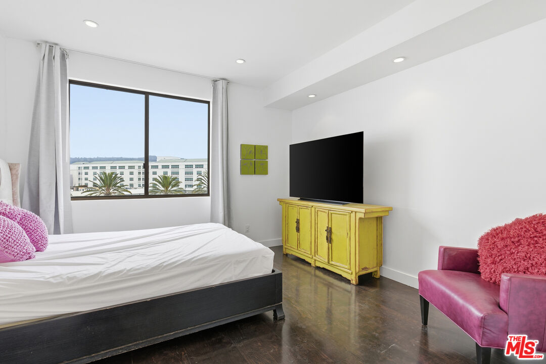 121 South Canon Drive, Unit PH 401 Beverly Hills, CA 90212 - Photo 16 of 31 a bedroom with a bed and a flat screen tv