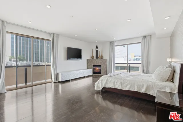 a spacious bedroom with a large bed and a flat tv screen