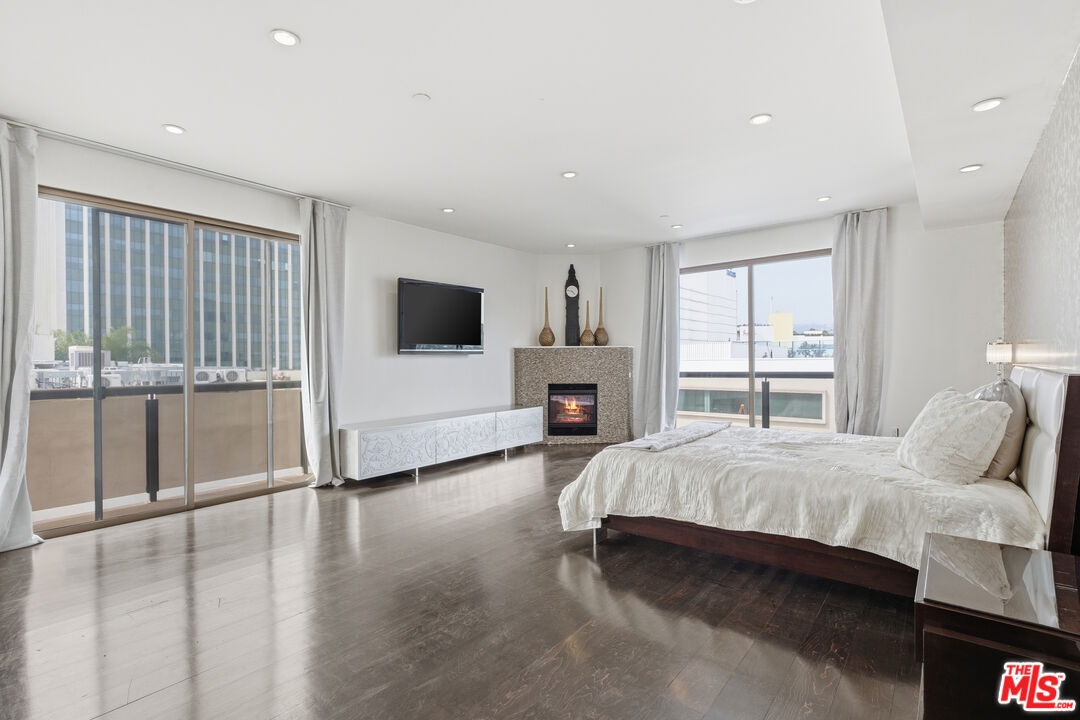 121 South Canon Drive, Unit PH 401 Beverly Hills, CA 90212 - Photo 20 of 31 a spacious bedroom with a large bed and a flat tv screen
