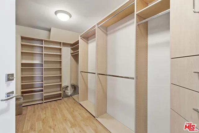 a view of walk in closet with empty racks