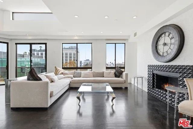 a living room with furniture a large window and a fireplace