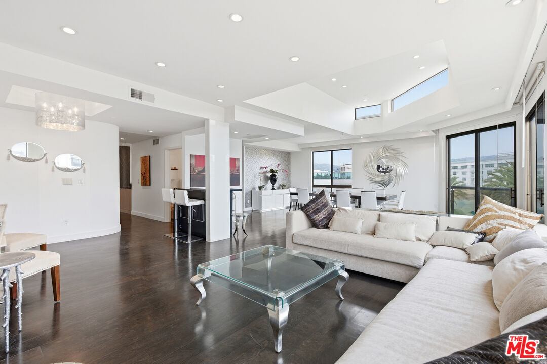 121 South Canon Drive, Unit PH 401 Beverly Hills, CA 90212 - Photo 6 of 31 a living room with furniture and a large window