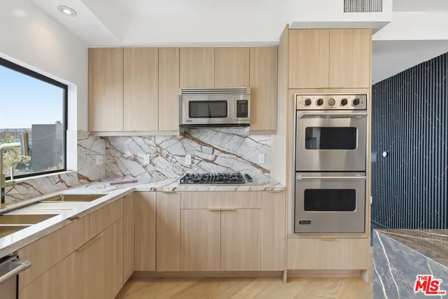 a kitchen with kitchen island granite countertop a stove a sink and a microwave
