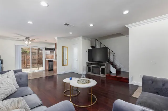 a living room with furniture a dining table and a flat screen tv