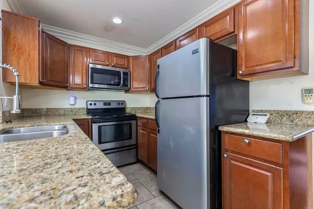 a kitchen with stainless steel appliances granite countertop a refrigerator stove a sink dishwasher and microwave oven