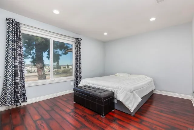 a bed sitting in a spacious bedroom next to a window