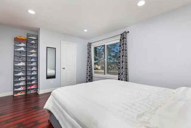 a spacious bedroom with a bed and a wooden floor