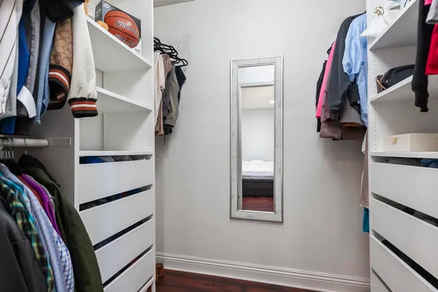 a view of walk in closet with clothes and shoes