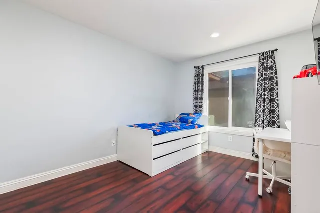a living room with hard wood floors and white walls