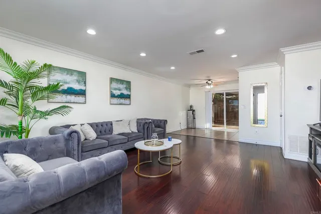 a living room with furniture and a wooden floor