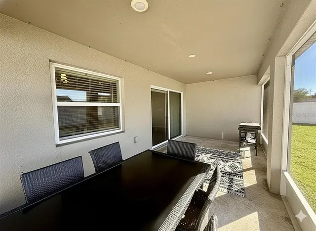 a view of an empty room with wooden floor and a fireplace