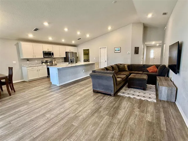 a living room with furniture and a wooden floor