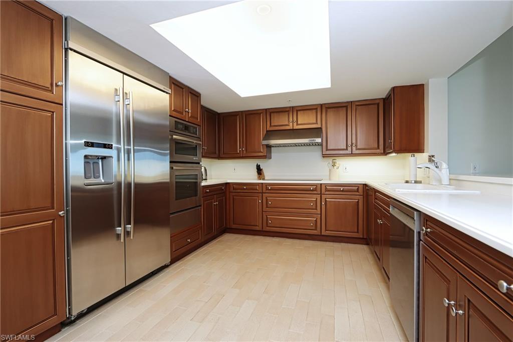 60 Seagate Drive, Unit 704 Naples, FL 34103 - Photo 11 of 28 a kitchen with stainless steel appliances a refrigerator and a sink