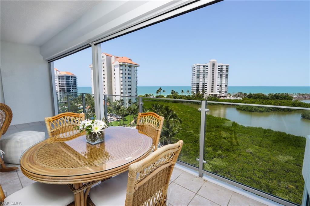 60 Seagate Drive, Unit 704 Naples, FL 34103 - Photo 3 of 28 a balcony with table and chairs