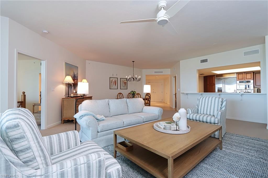 60 Seagate Drive, Unit 704 Naples, FL 34103 - Photo 6 of 28 a living room with furniture and a wooden floor