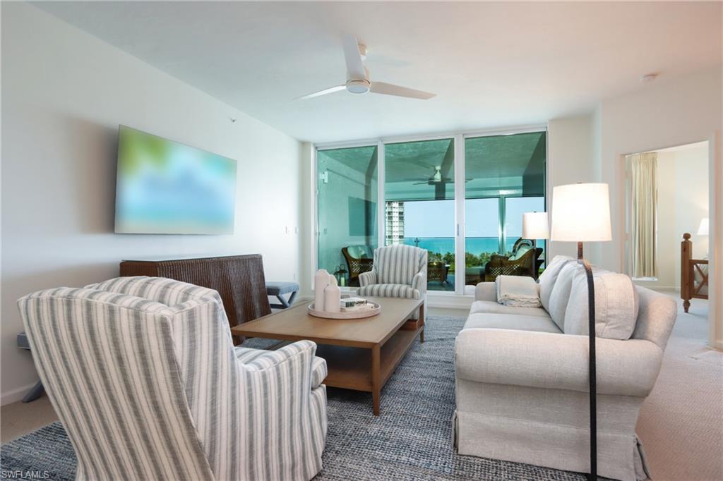 60 Seagate Drive, Unit 704 Naples, FL 34103 - Photo 8 of 28 a living room with furniture and a large window