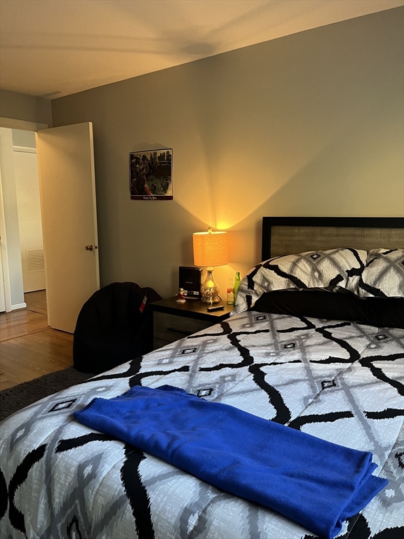 38 Dunham Road, Unit 109 Beverly, MA 01915 - Photo 15 of 24 a bed sitting in a bedroom next to a window with wooden floor
