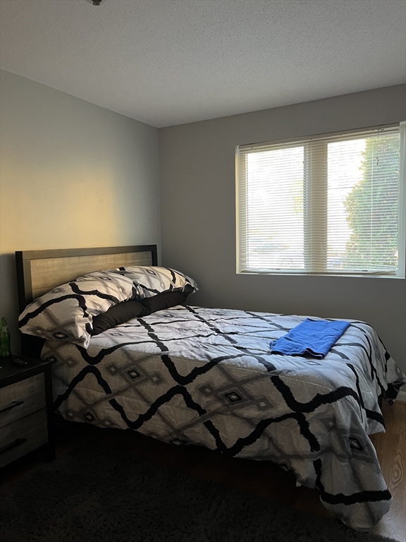 38 Dunham Road, Unit 109 Beverly, MA 01915 - Photo 16 of 24 a bed sitting in a bedroom next to a window