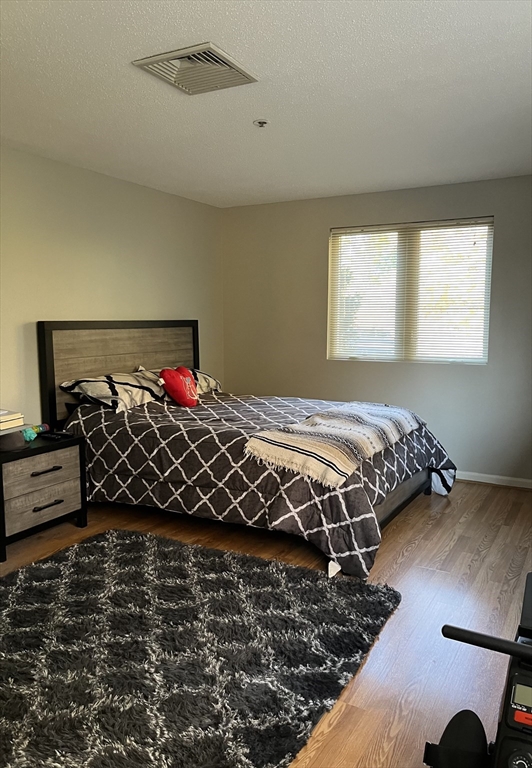 38 Dunham Road, Unit 109 Beverly, MA 01915 - Photo 18 of 24 a bed sitting in a bedroom next to a window
