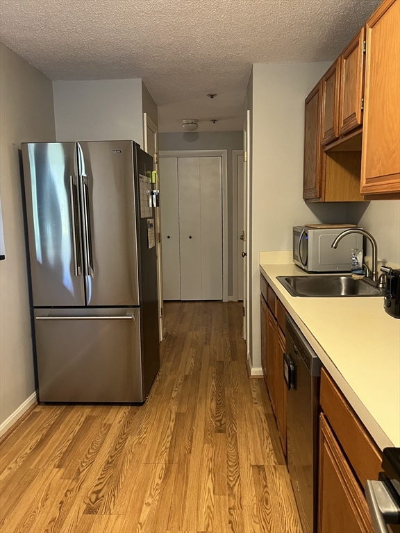 38 Dunham Road, Unit 109 Beverly, MA 01915 - Photo 5 of 24 a kitchen with a sink a refrigerator freezer a stove and a dishwasher