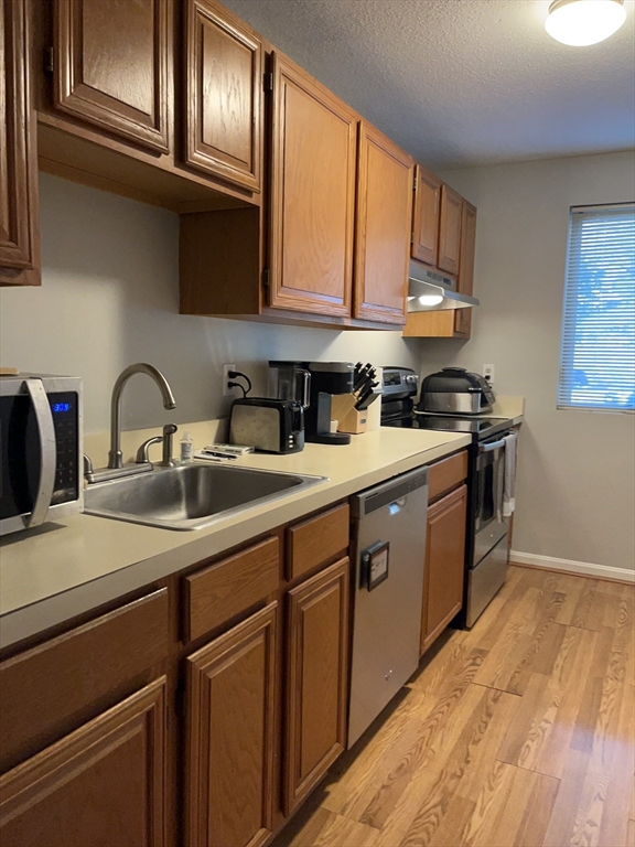 38 Dunham Road, Unit 109 Beverly, MA 01915 - Photo 6 of 24 a kitchen with stainless steel appliances granite countertop a sink stove and cabinets