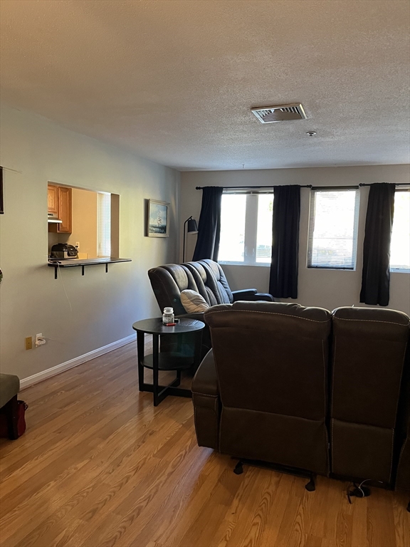 38 Dunham Road, Unit 109 Beverly, MA 01915 - Photo 9 of 24 a living room with furniture and a flat screen tv
