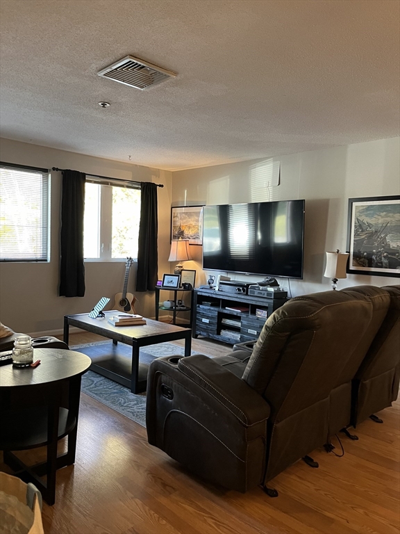 38 Dunham Road, Unit 109 Beverly, MA 01915 - Photo 10 of 24 a living room with furniture and a flat screen tv