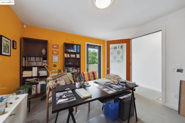 a view of a workspace with furniture and a bookshelf