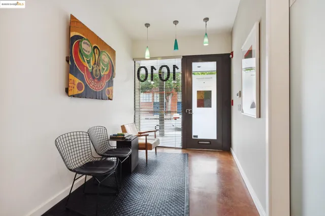 a hallway with couches and dining table with wooden floor