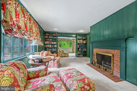 a living room with furniture a fireplace and a large window