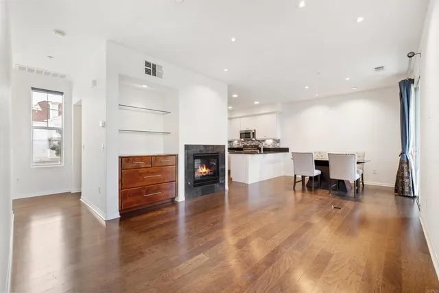 a living room with furniture and a dining table with kitchen view