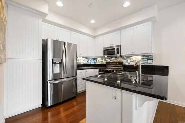 a kitchen with granite countertop a refrigerator stove and microwave