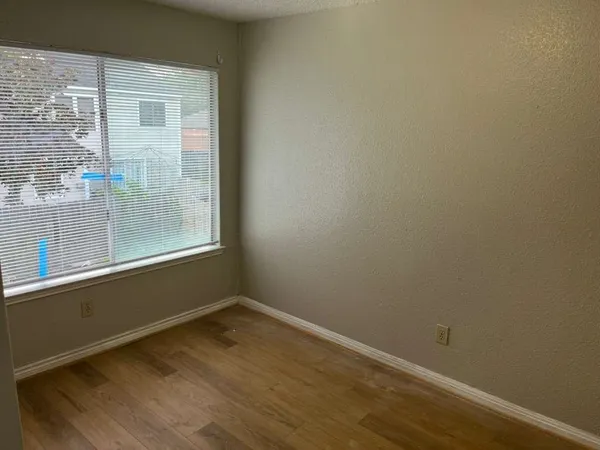 a view of a small space with wooden floor and a window