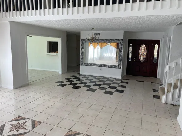 a kitchen with granite countertop a stove and a flat screen tv