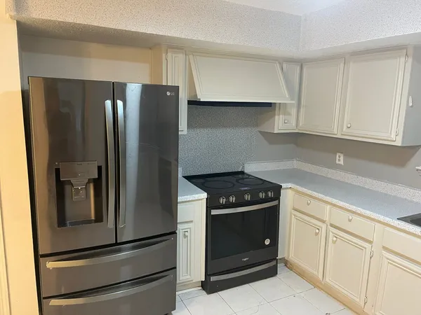 a kitchen with white cabinets and stainless steel appliances