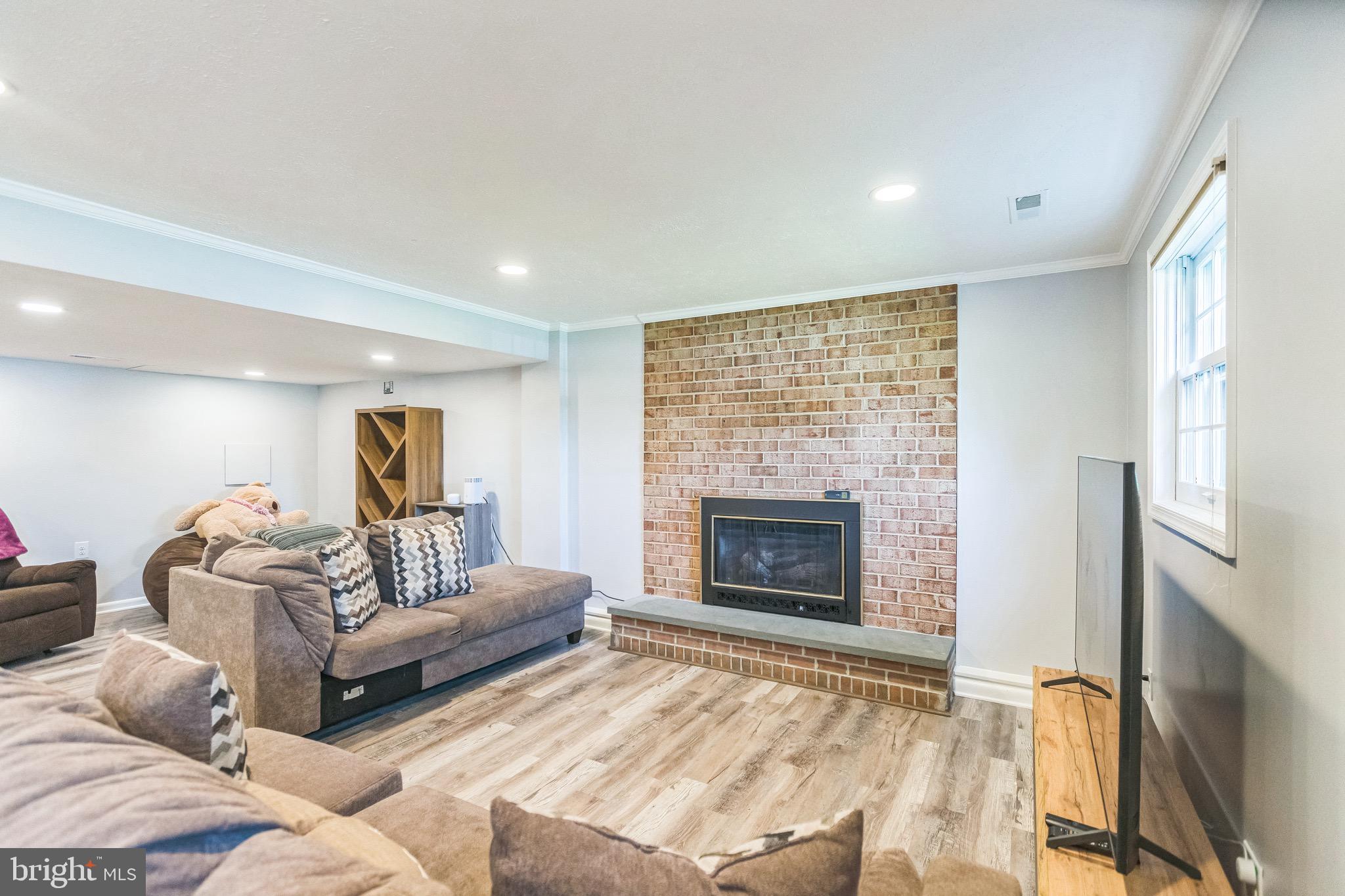 4008 Briars Road Olney, MD 20832 - Photo 22 of 32 a living room with furniture a fireplace and a flat screen tv