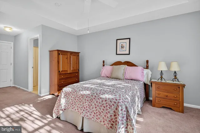 a bedroom with a bed and a lamp on dresser