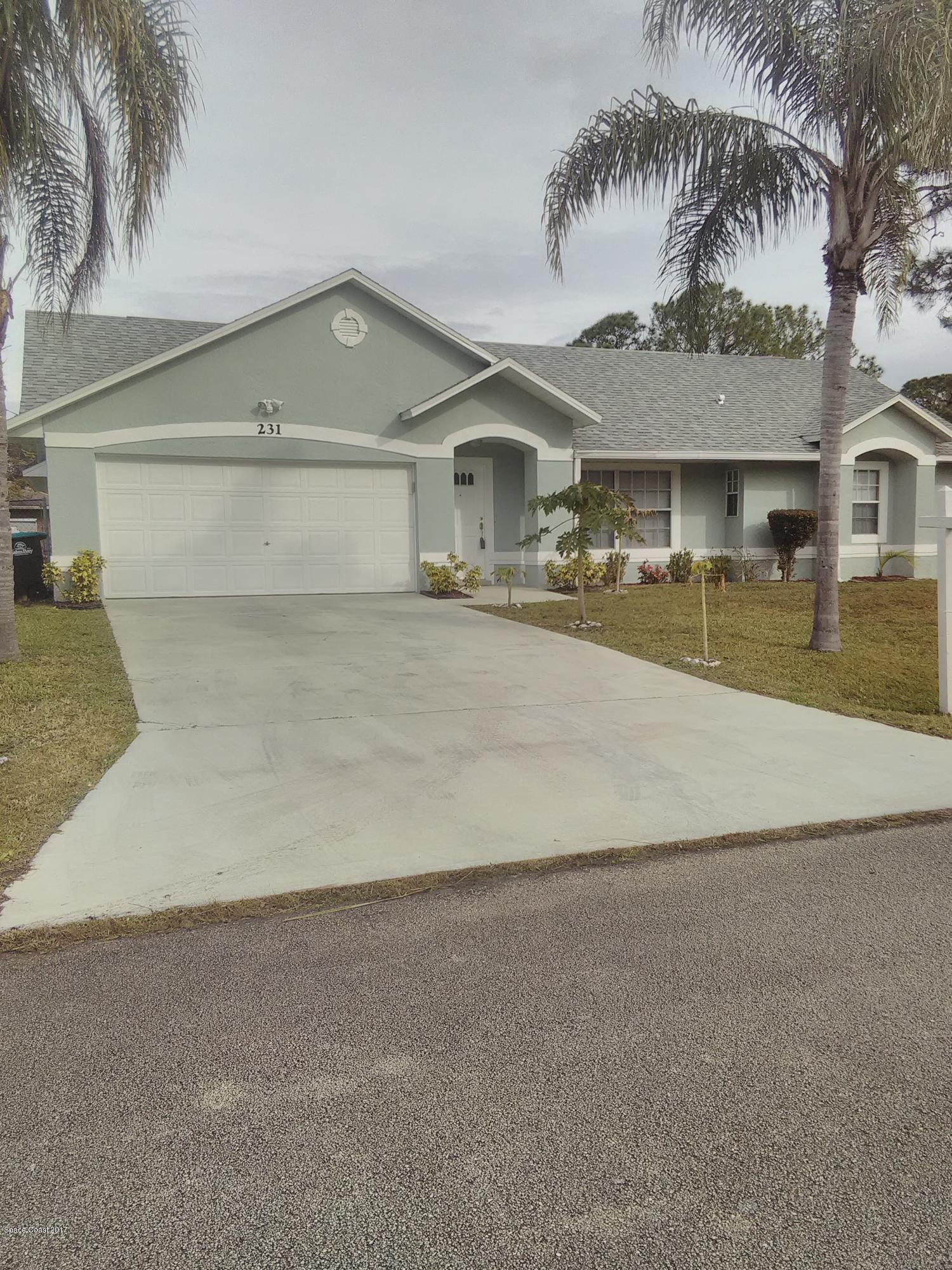 231 Rheine Road Northwest Palm Bay, FL 32907 - Photo 1 of 10 a front view of a house with a yard