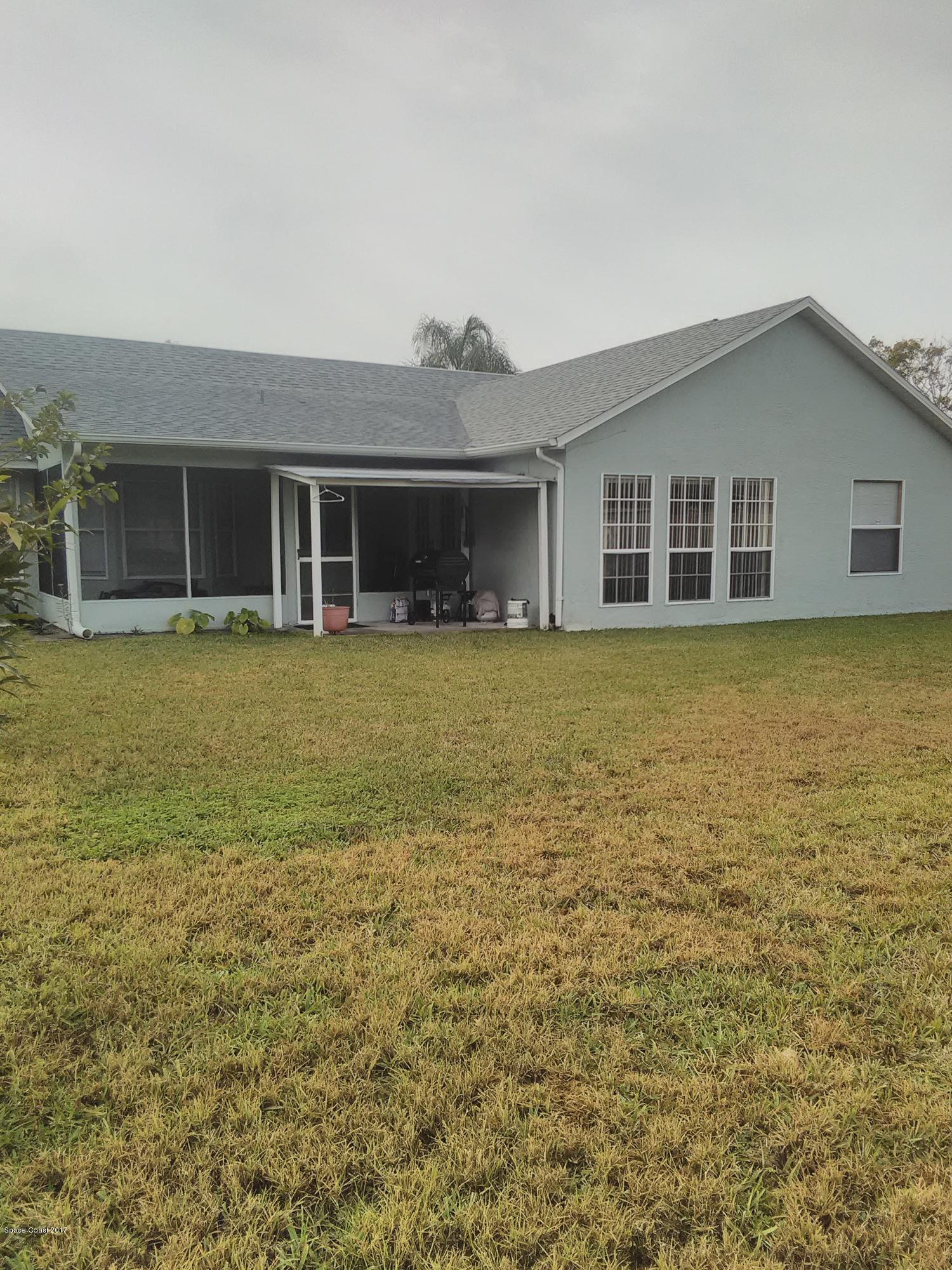231 Rheine Road Northwest Palm Bay, FL 32907 - Photo 2 of 10 a front view of a house with a yard