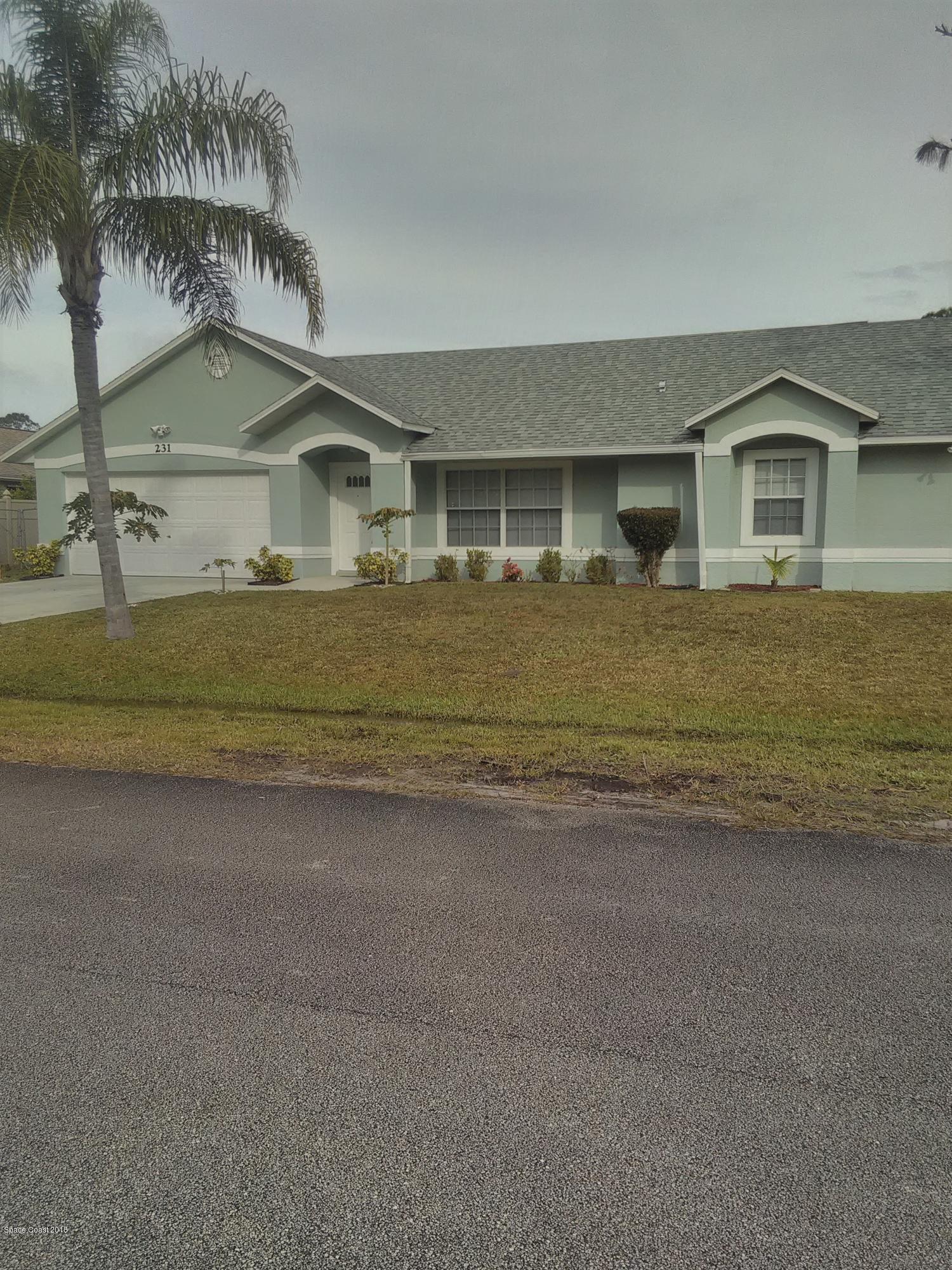231 Rheine Road Northwest Palm Bay, FL 32907 - Photo 3 of 10 a front view of a house with a yard