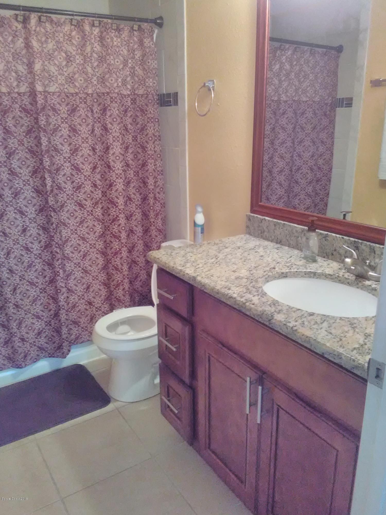 231 Rheine Road Northwest Palm Bay, FL 32907 - Photo 10 of 10 a bathroom with a granite countertop sink toilet and mirror