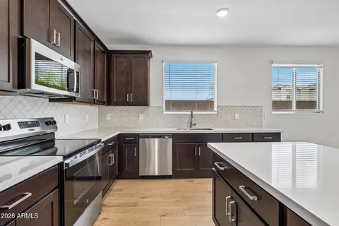 a kitchen with a sink stove top oven and cabinets