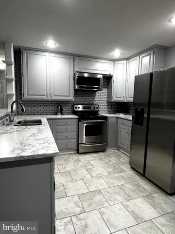 a kitchen with stainless steel appliances granite countertop a sink a stove a microwave a counter top and cabinets