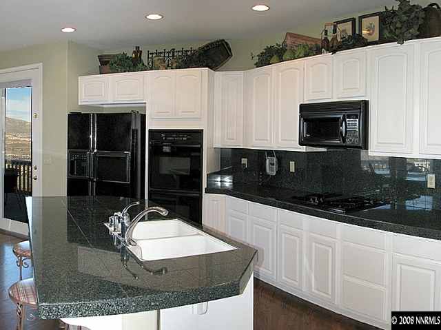4871 Grousecreek Court Reno, NV 89519 - Photo 5 of 9 a kitchen with stainless steel appliances granite countertop a sink and white cabinets
