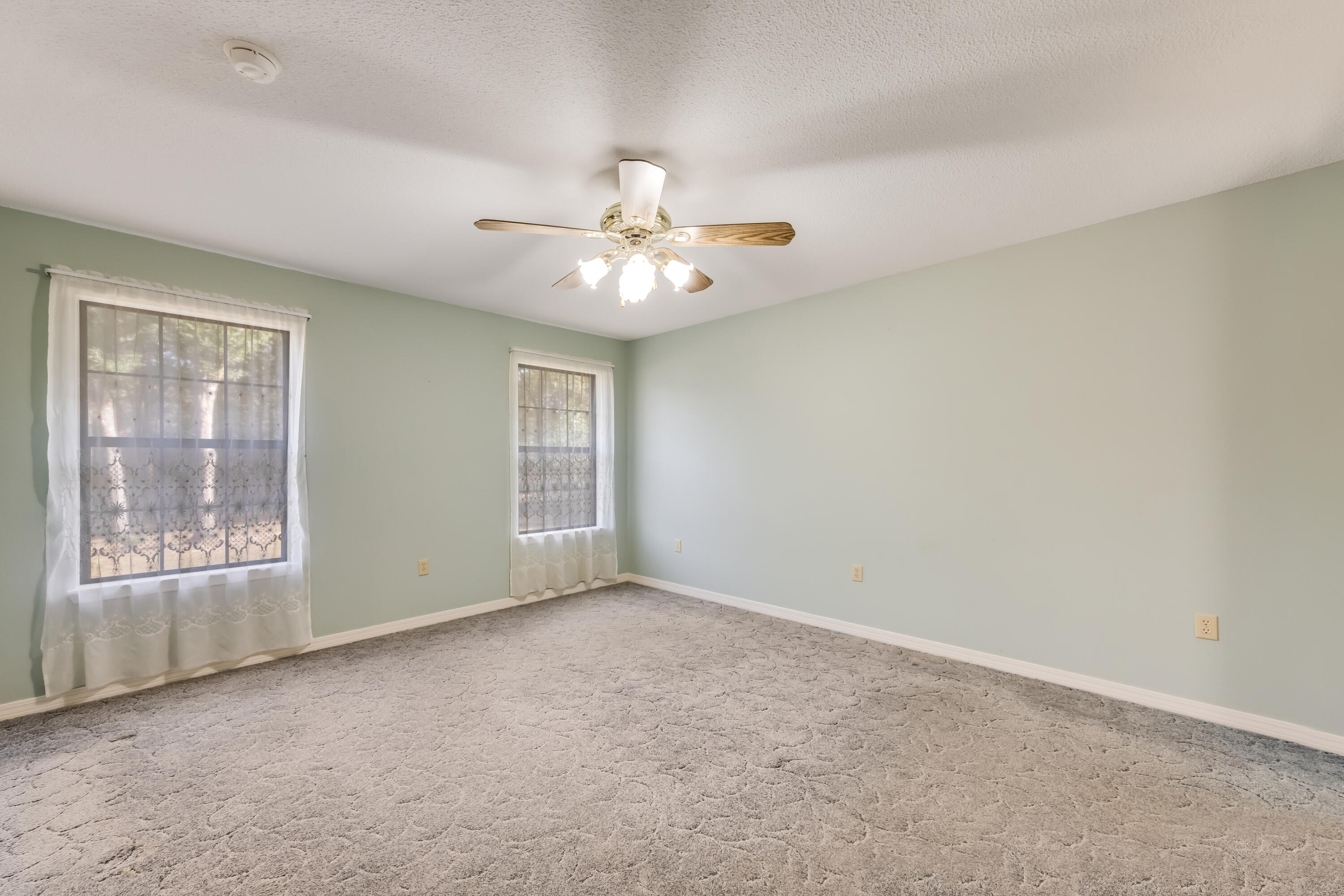 5965 Oak Hill Road Crestview, FL 32536 - Photo 16 of 44 an empty room with windows and ceiling fan
