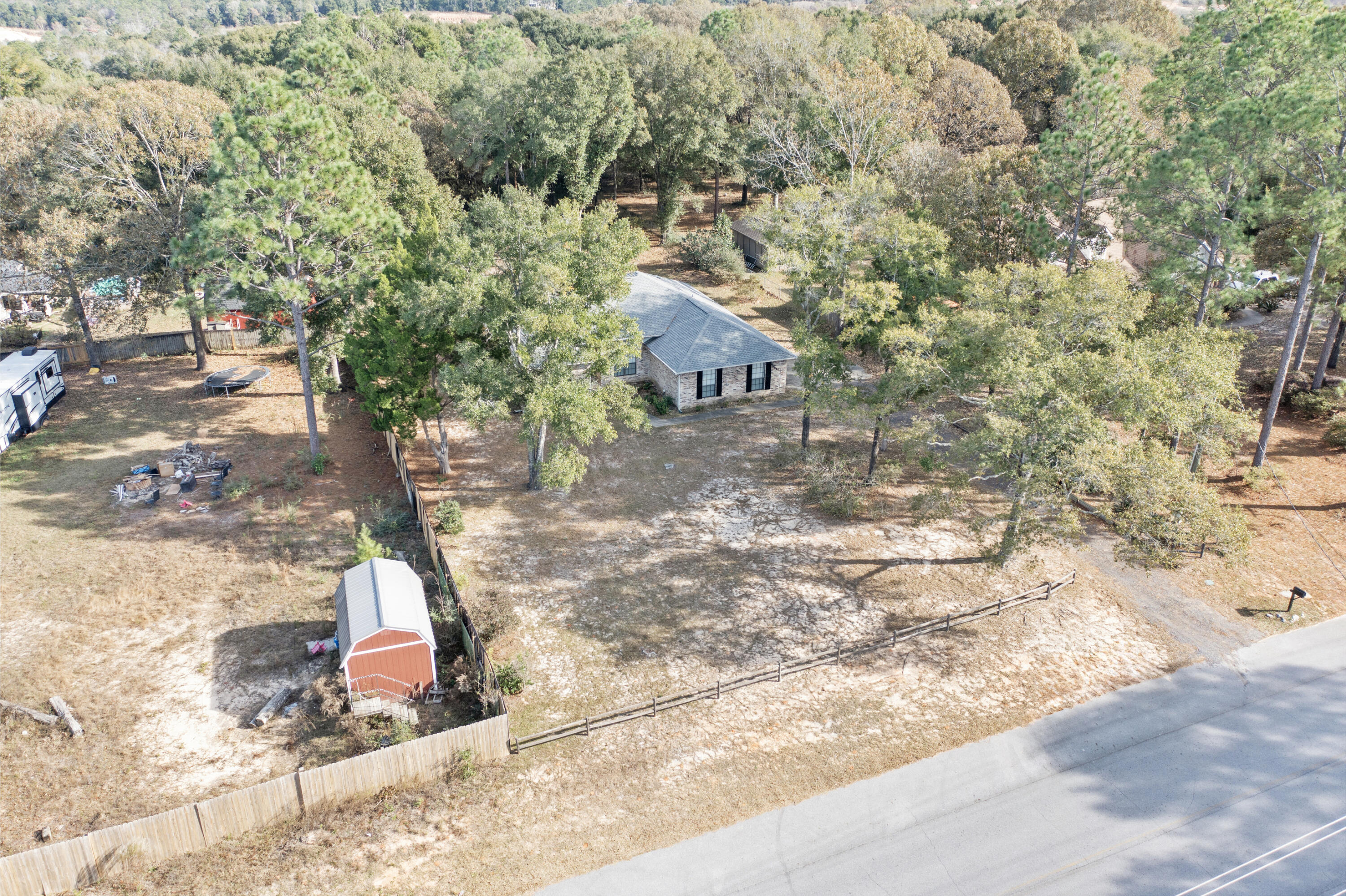 5965 Oak Hill Road Crestview, FL 32536 - Photo 40 of 44 a backyard of a house with large trees and covered with wooden fence