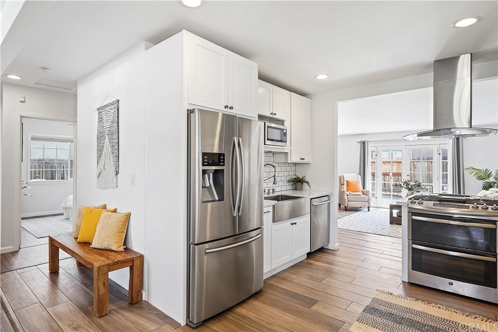 14709 Bodger Avenue Hawthorne, CA 90250 - Photo 6 of 24 a kitchen with white cabinets and stainless steel appliances