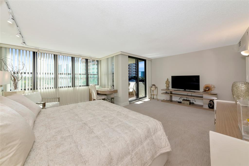 101 Sunset Drive, Unit PH3 Sarasota, FL 34236 - Photo 12 of 47 a spacious bedroom with a bed and a flat screen tv