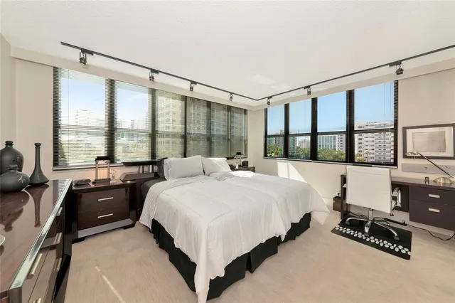 a bedroom with a bed and a large window