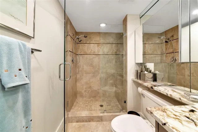 a bathroom with a granite countertop sink toilet and shower